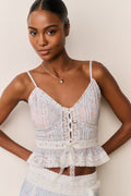 Woman wearing a light blue floral skirt and top against a beige background
