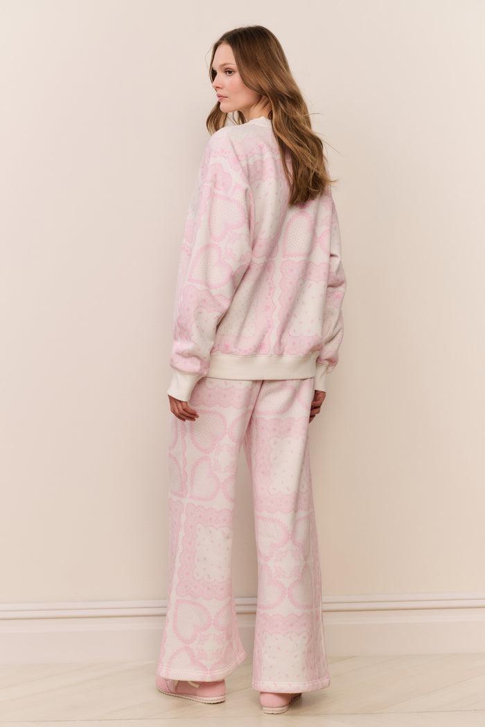 Woman wearing a pink printed pajama set against a plain background
