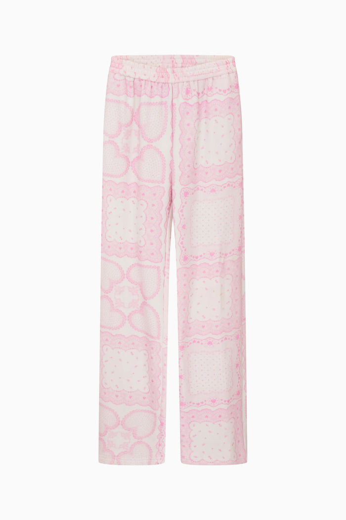 Woman wearing a pink printed pajama set against a plain background