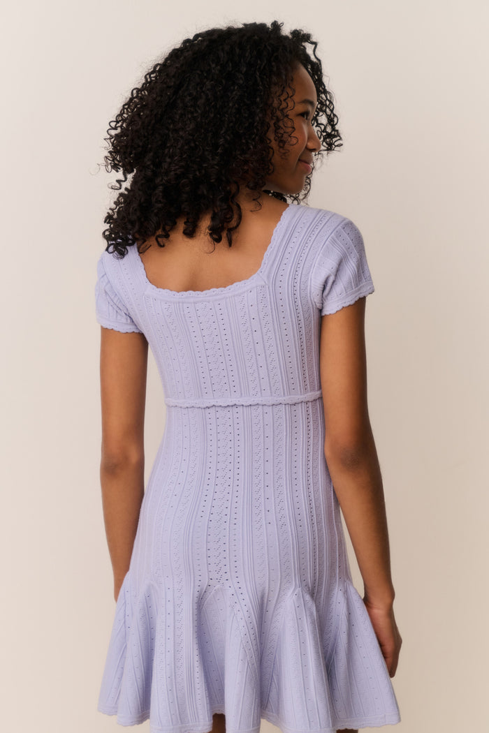 Girl wearing a light purple dress against a plain background